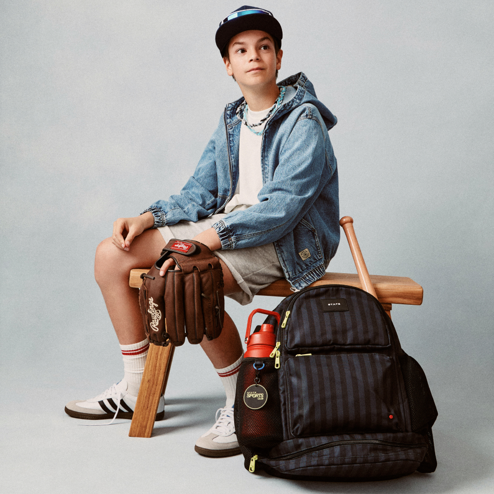 Boy sitting with STATE Bags Shea Backpack Black Gray Striped