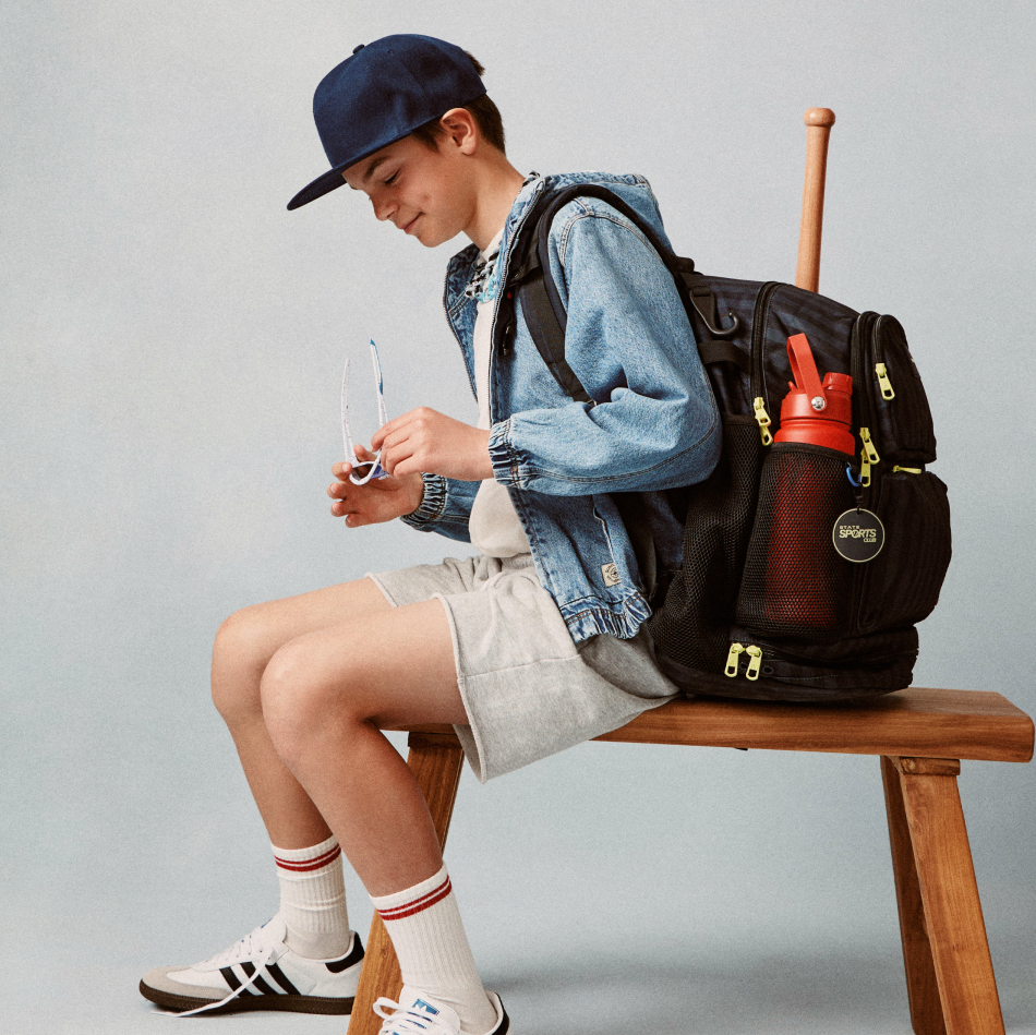 Boy sitting with STATE Bags Shea Backpack Black Gray Striped