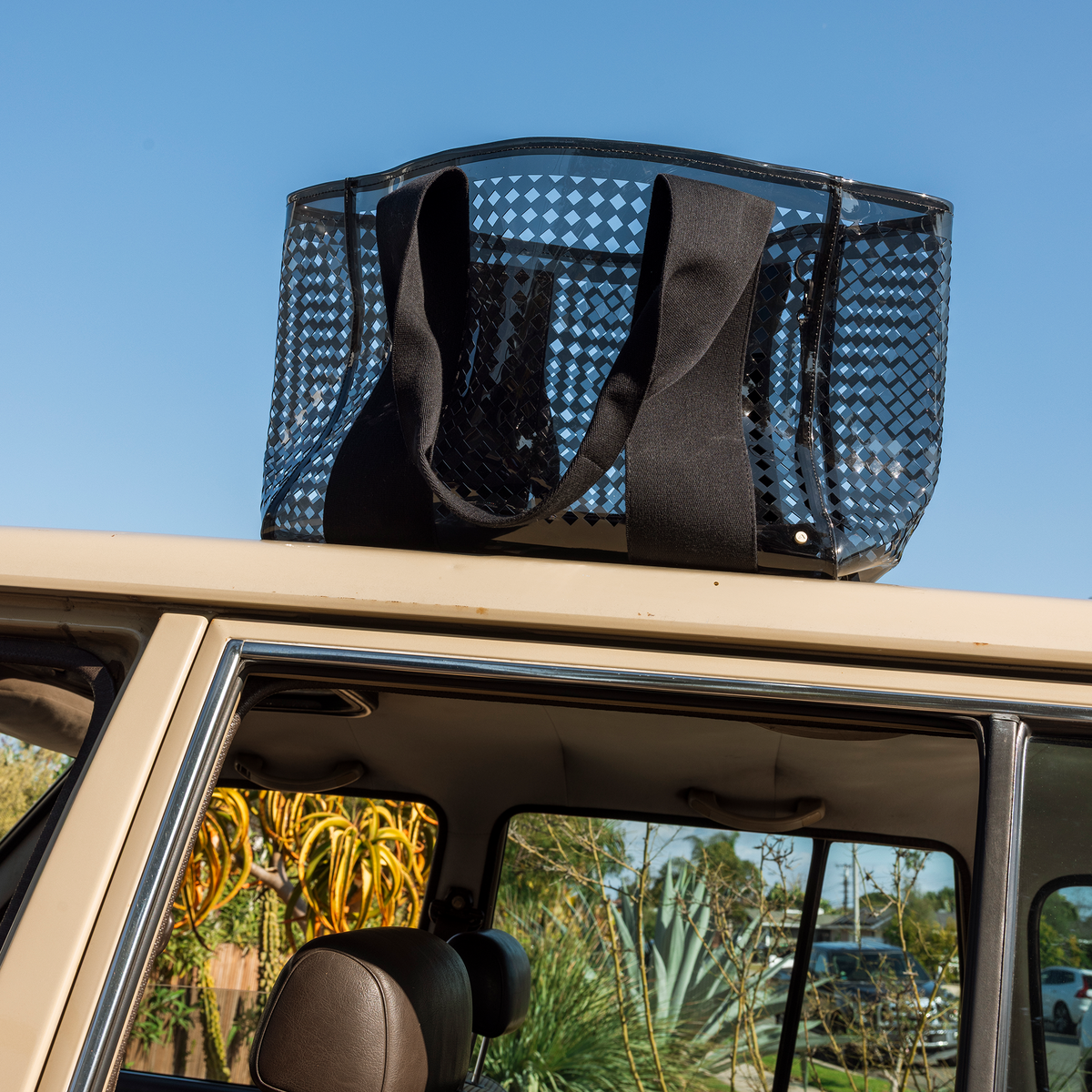 STATE Bags Wellington Cabana Tote Black Perforated sitting on top of a car