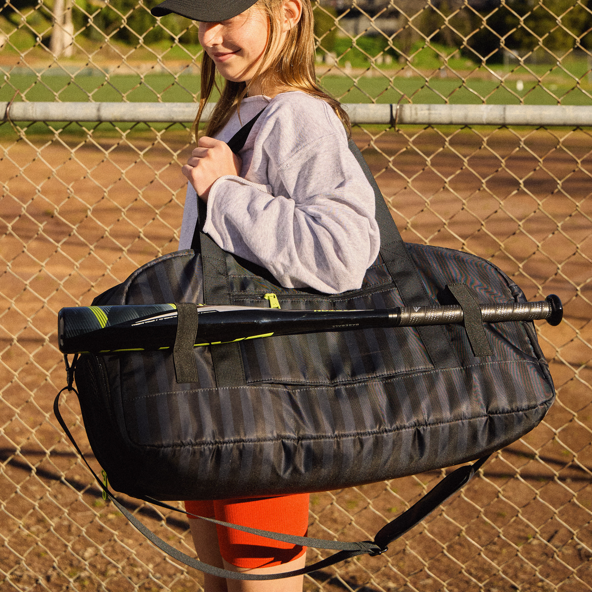 Girl holding STATE Bags Fenway Sports Duffle in Black Gray Striped