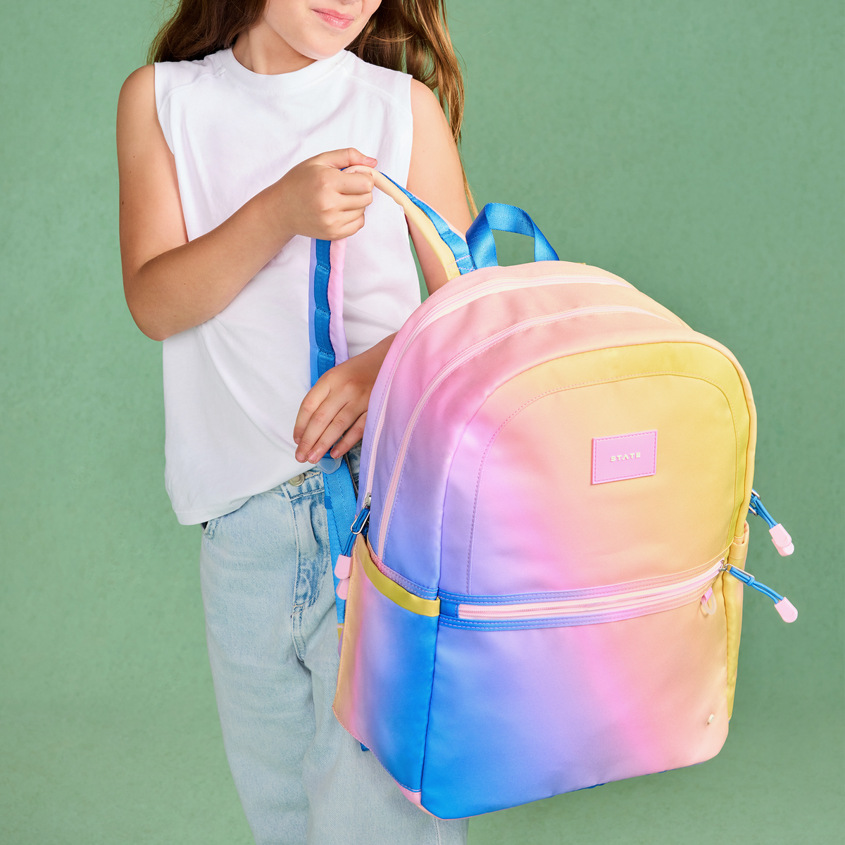 girl holding STATE Bags Kane Double Pocket Large Backpack Blue/Pink/Yellow Gradient