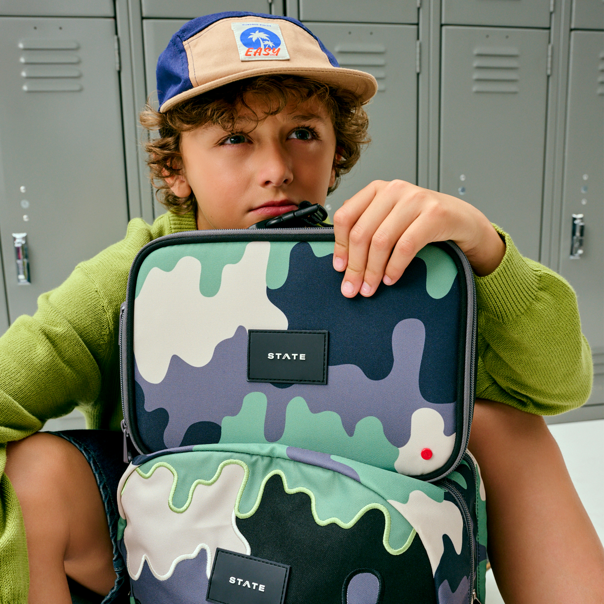 boy holding Rodgers Lunch Box camo drip