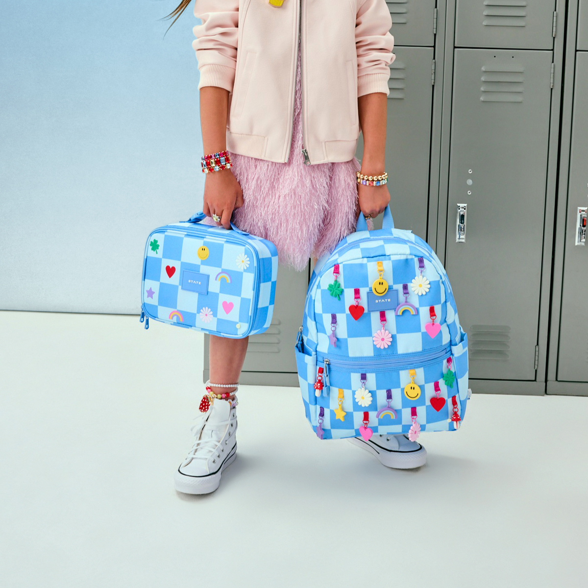 girl holding Kane Backpack charms blue check