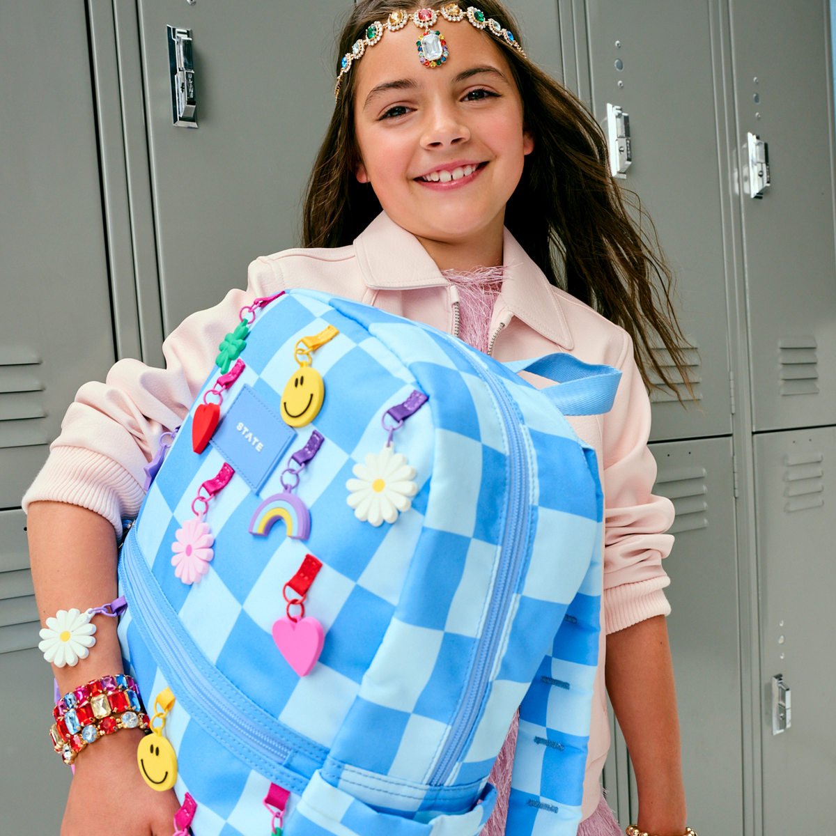 girl holding Kane Backpack charms blue check
