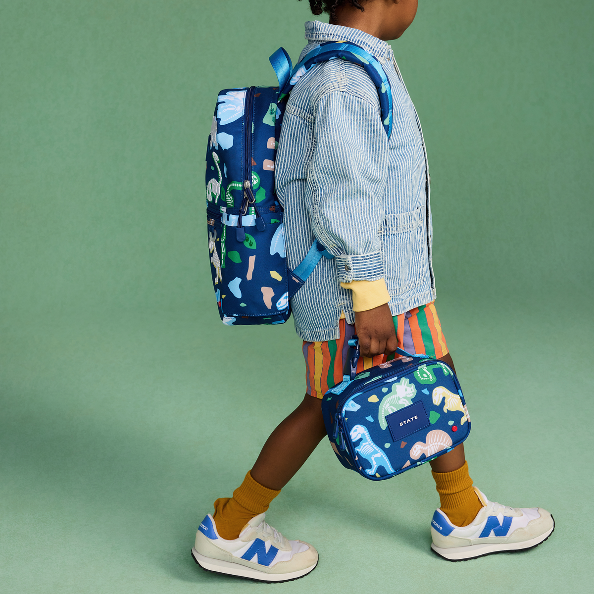 boy wearing Kane Mini Backpack dino fossils