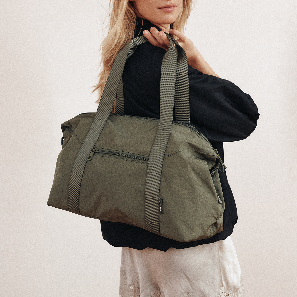 Woman wearing STATE Bags Harlow Carryall Crinkle Nylon Olive