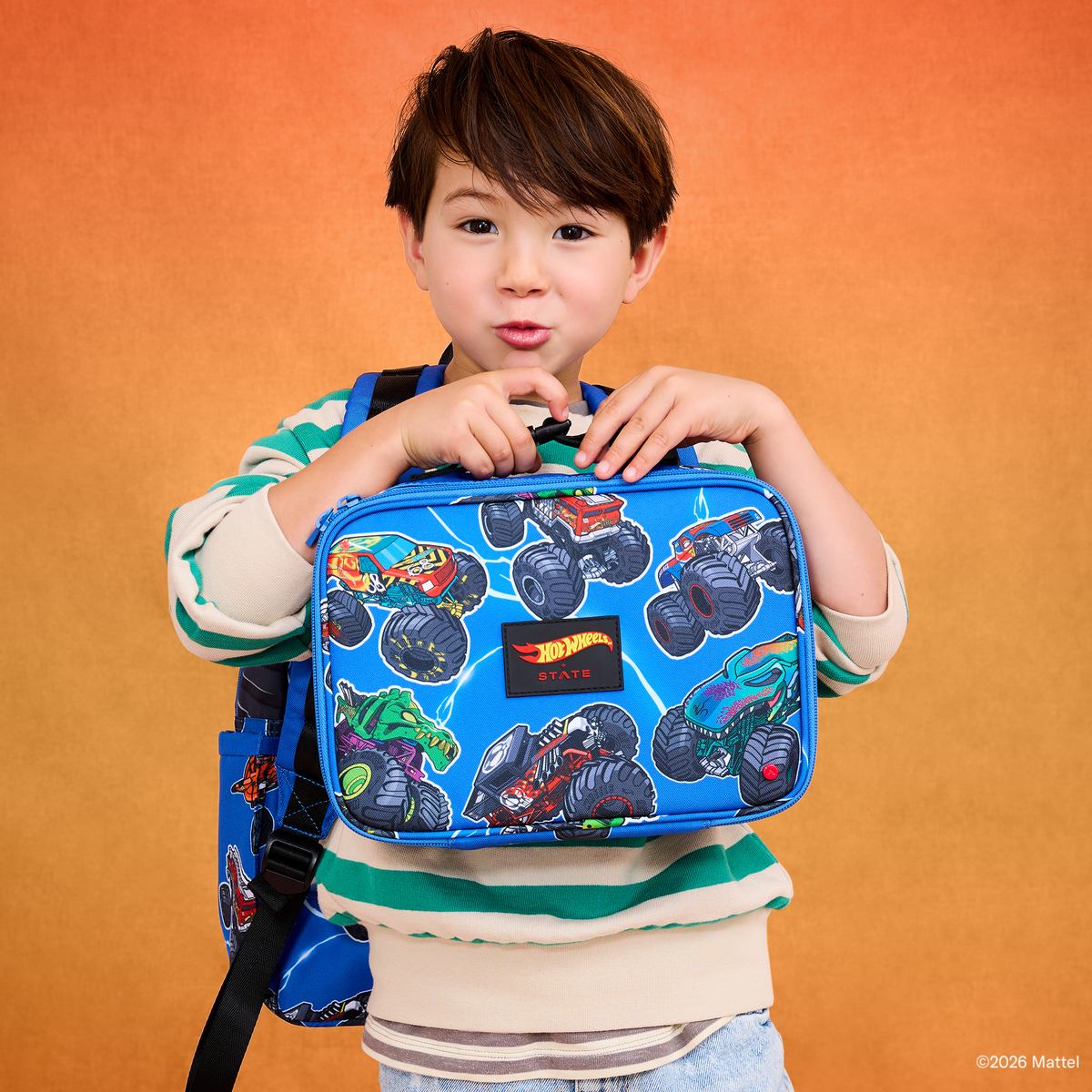Boy holding STATE x Hot Wheels™ Rodgers Lunch Box Falling Trucks