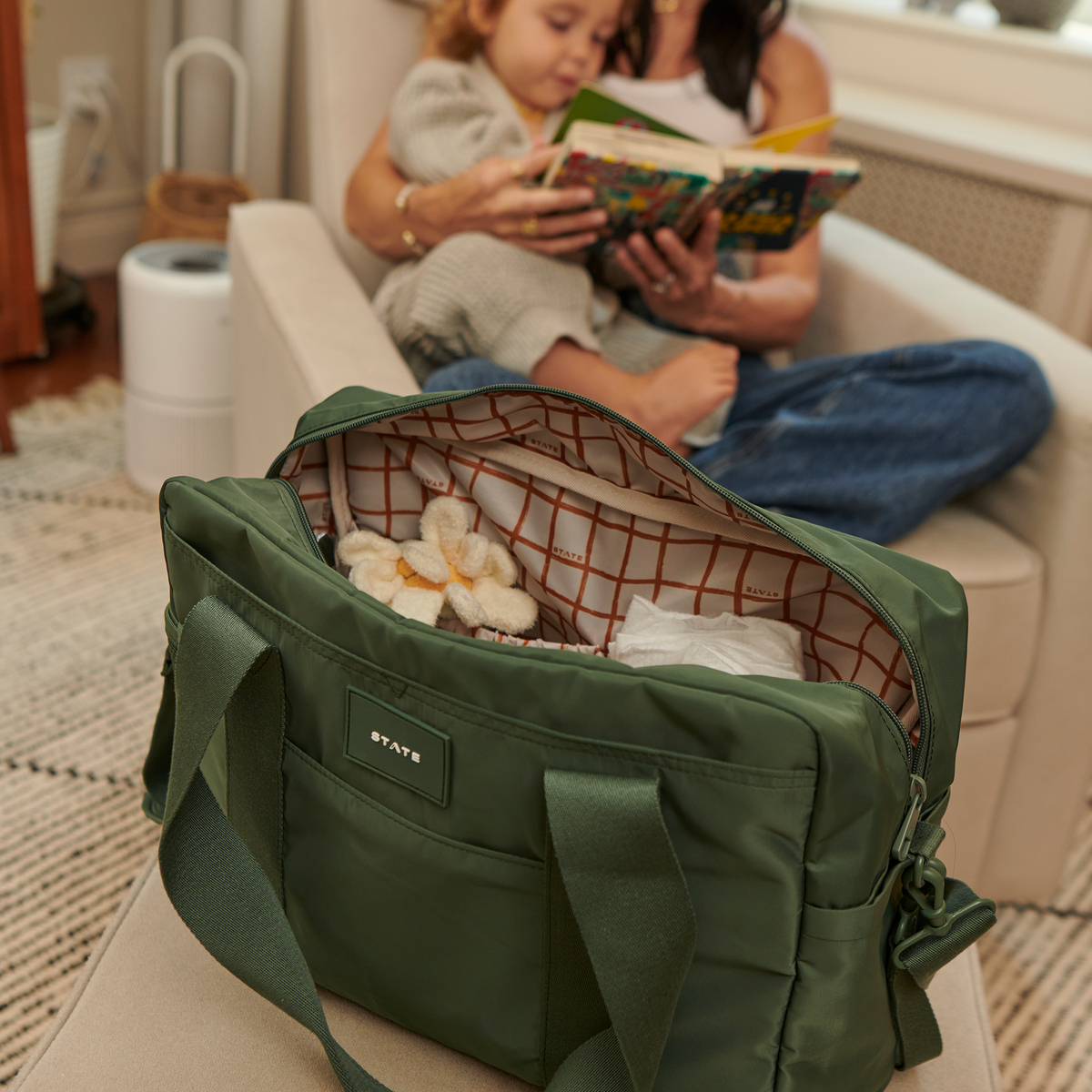 Jordan Diaper Tote Olive with Mom reading a book with her baby