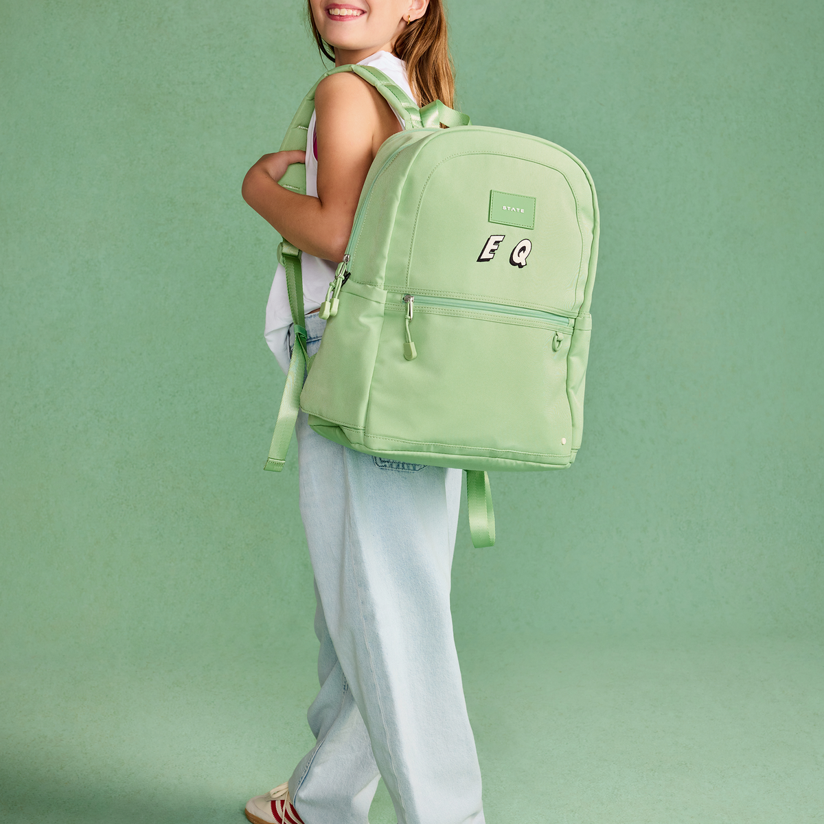 Girl wearing STATE Bags Kane Double Pocket Backpack Green
