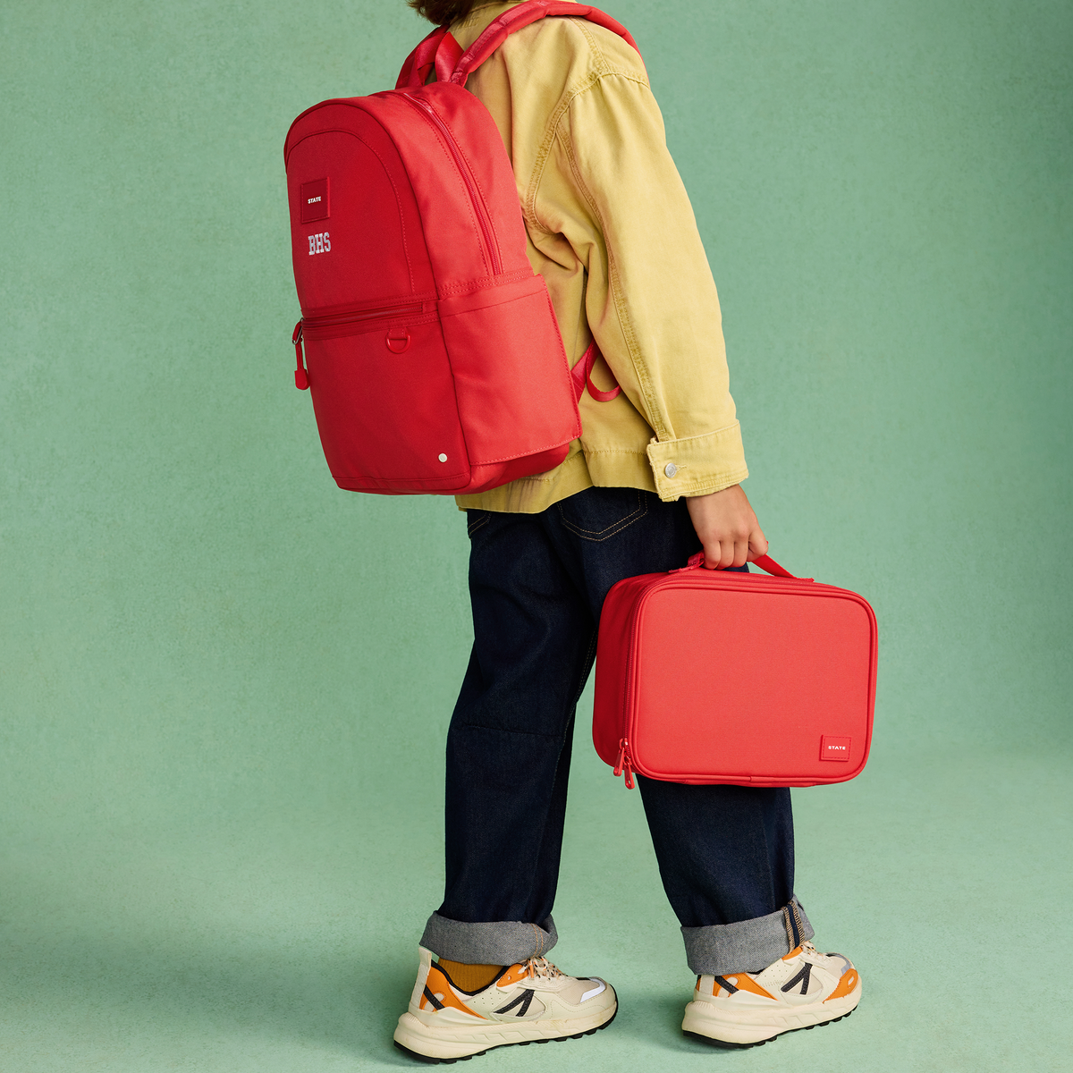 boy wearing kane backpack red