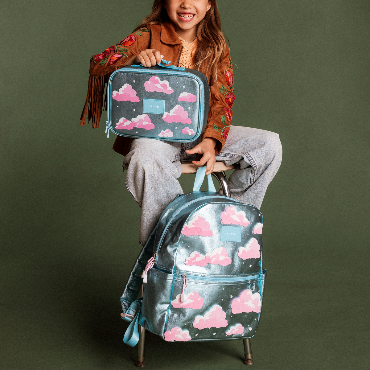 Girl holding STATE Bags Kane Backpack Clouds and Rodgers Lunch Box Clouds