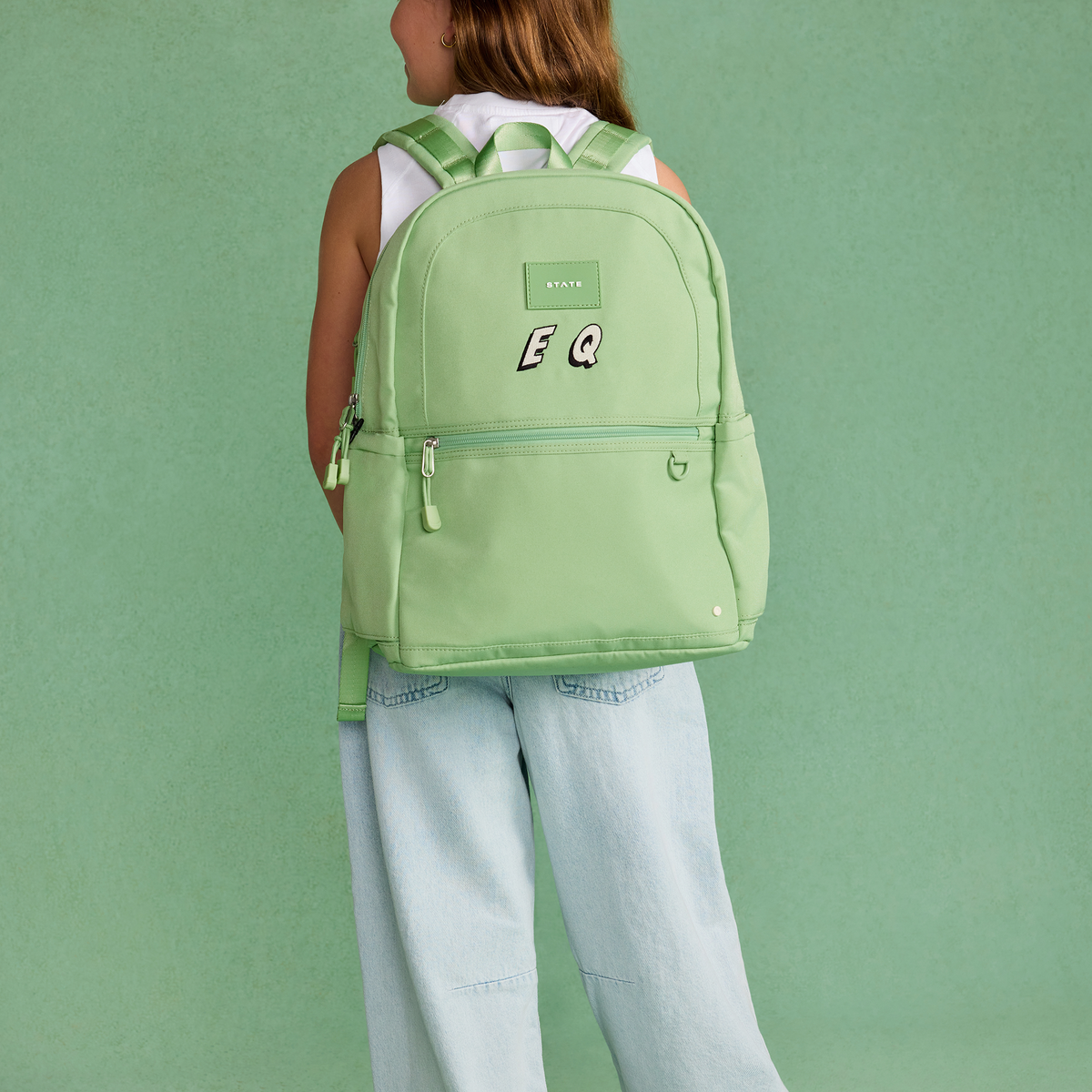 Girl wearing STATE Bags Kane Double Pocket Backpack Green