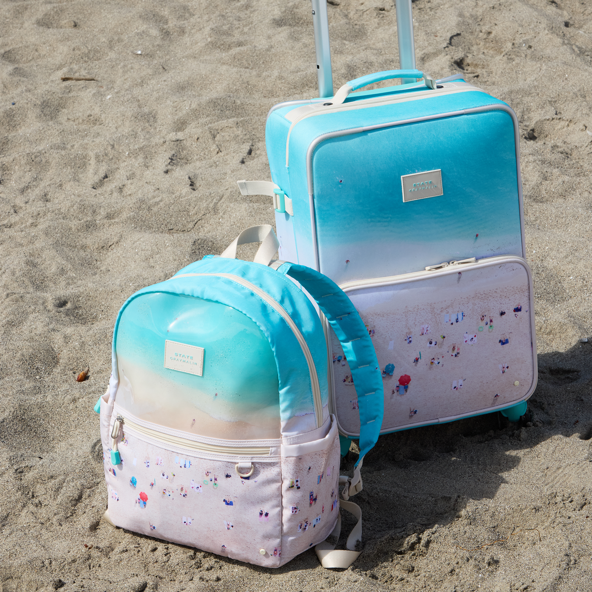  STATE x Gray Malin Logan Carry-On Suitcase on the beach in the sand