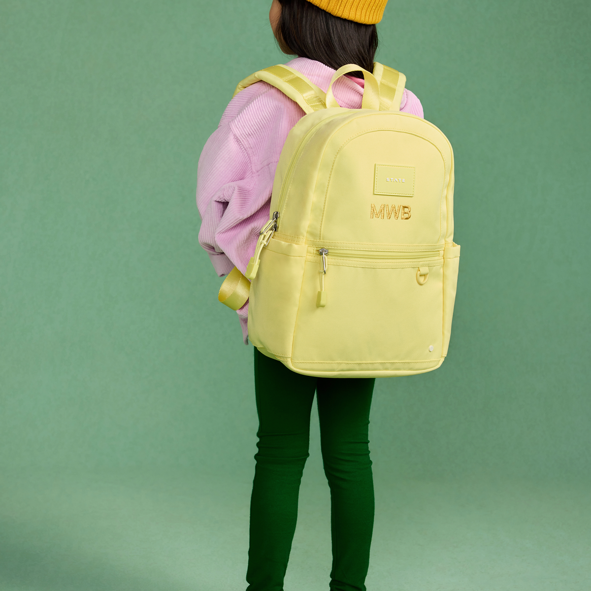 girl wearing kane mini backpack butter yellow