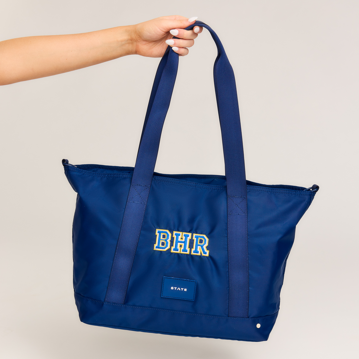 girl holding state bags graham totes in navy