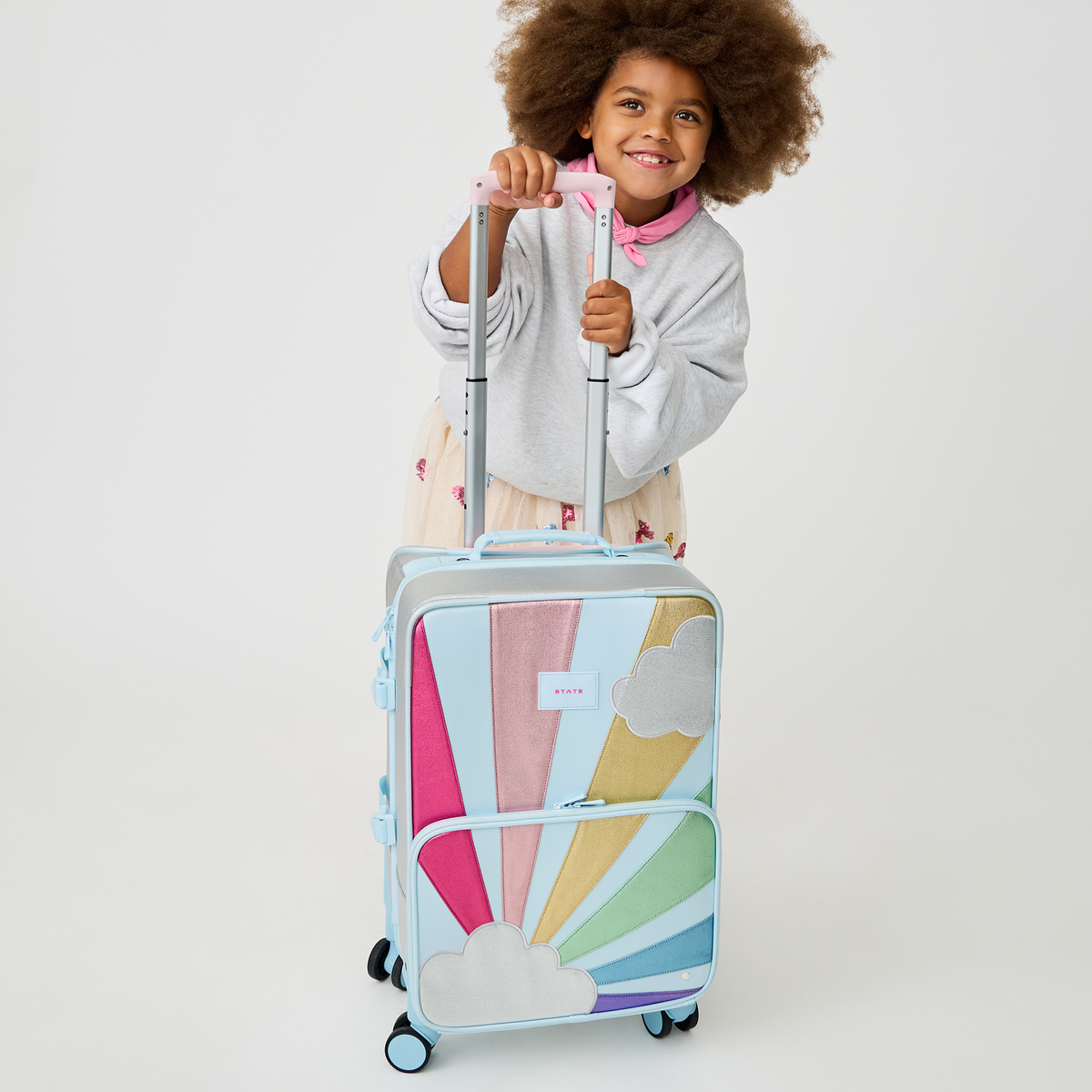 girl with STATE Bags Logan Carry-On Suitcase Rainbow Cloud 