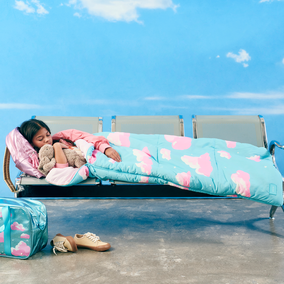 girl sleeping at airport with state bags redwood sleeping bag clouds