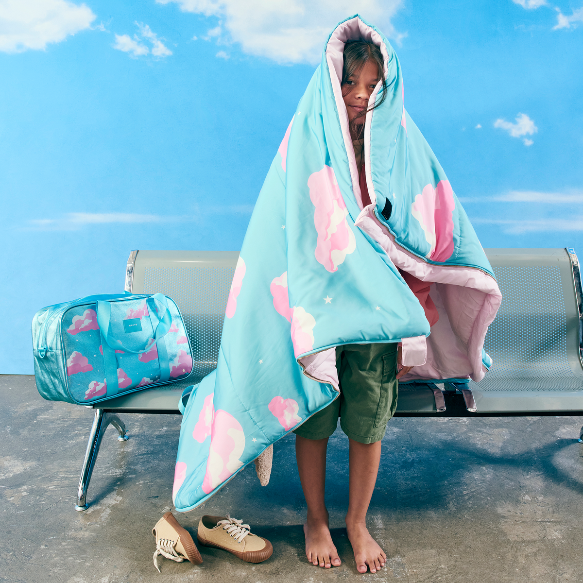 girl at airport with state bags redwood sleeping bag clouds