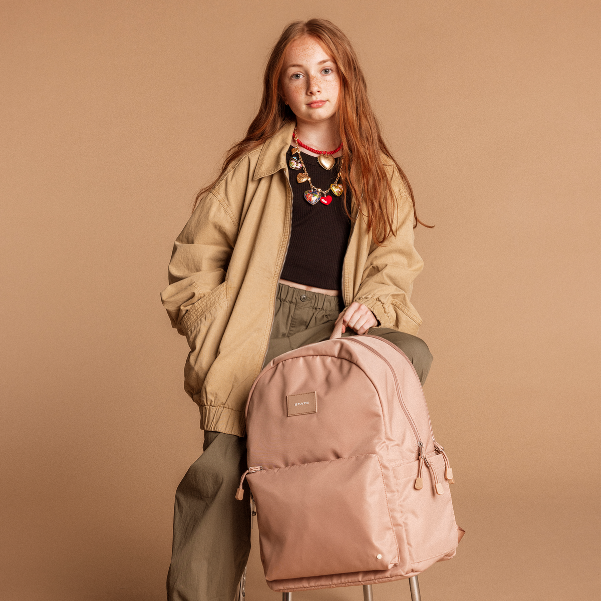 Girl Holding STATE Bags Reed Backpack Mocha