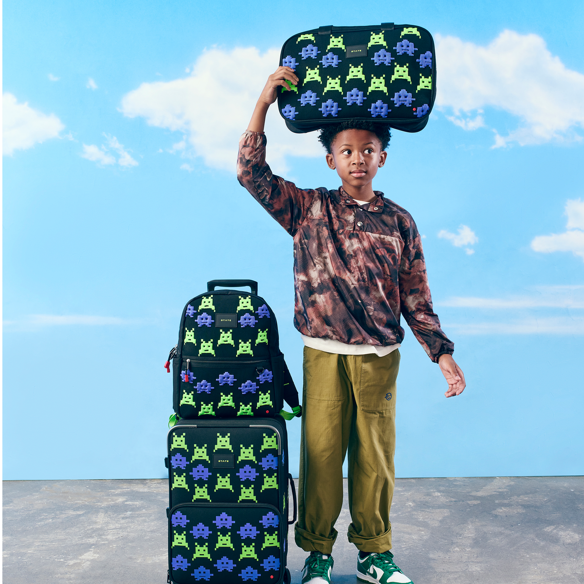 Boy holding STATE Bags Rockaway duffle arcade on his head
