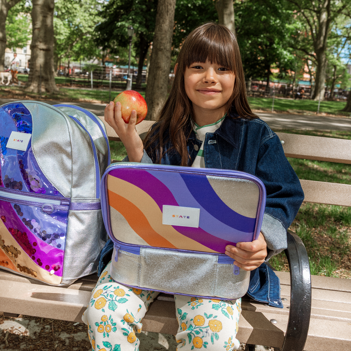 Girl siting on bench with rodgers and kane double pocket backpack sequin metallic