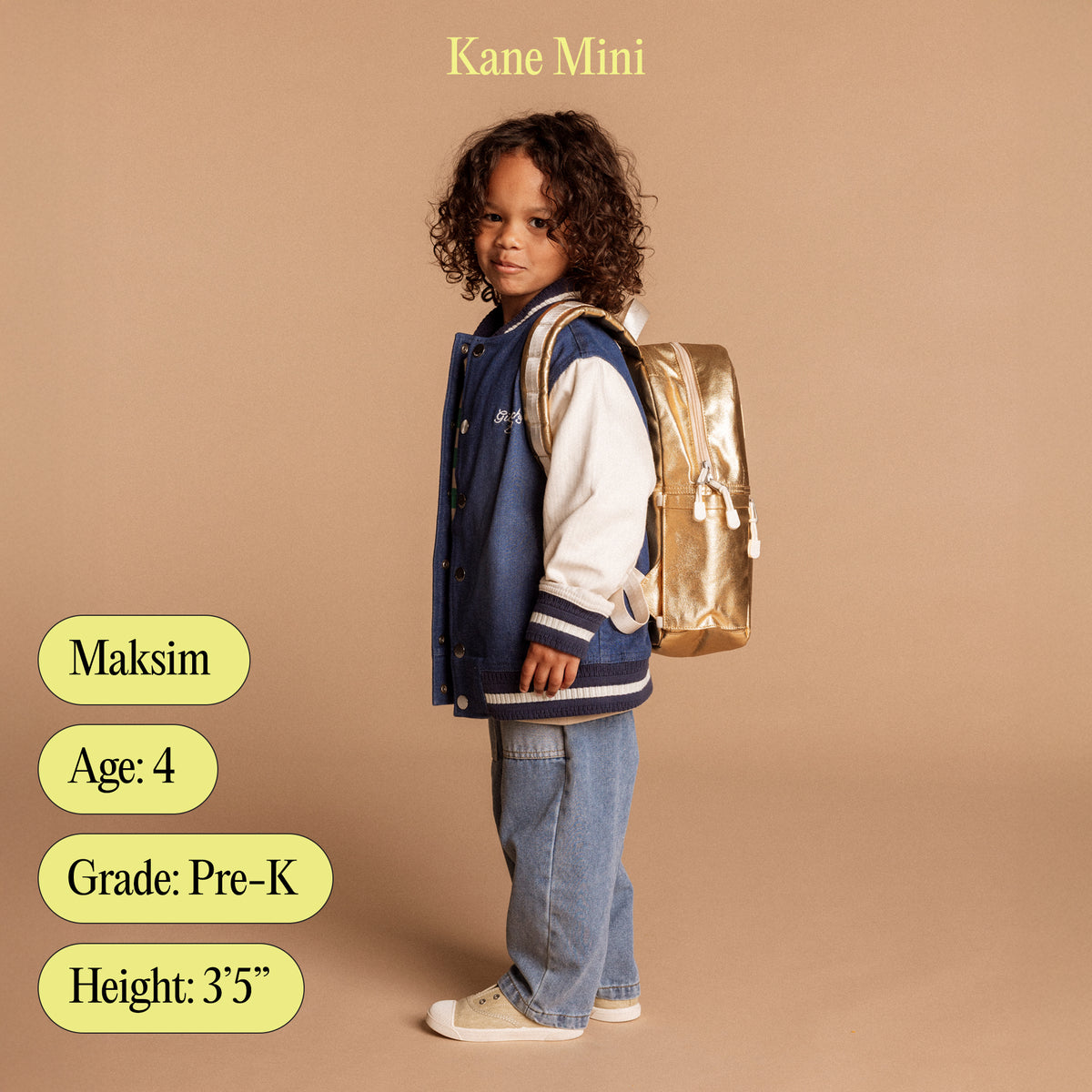 Boy wearing state bags kane mini backpack with age, grade, and height