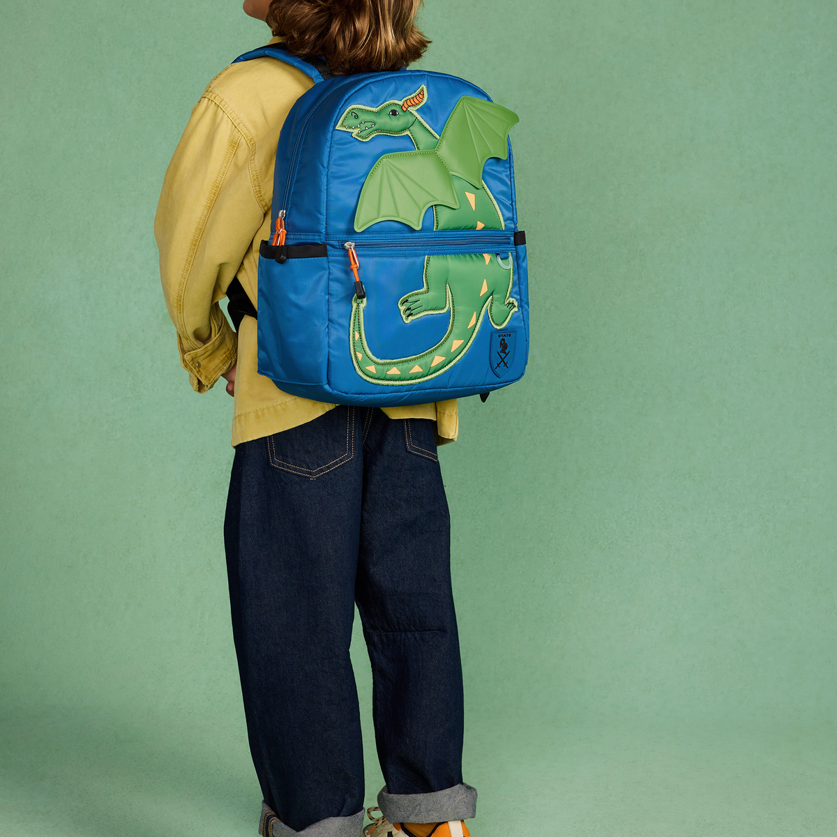 boy wearing kane backpack dragon 
