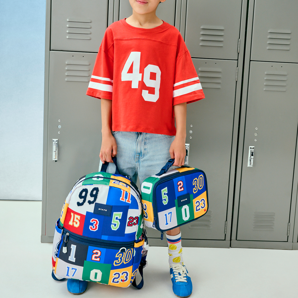Boy holding STATE Bags Kane Backpack Varsity Numbers