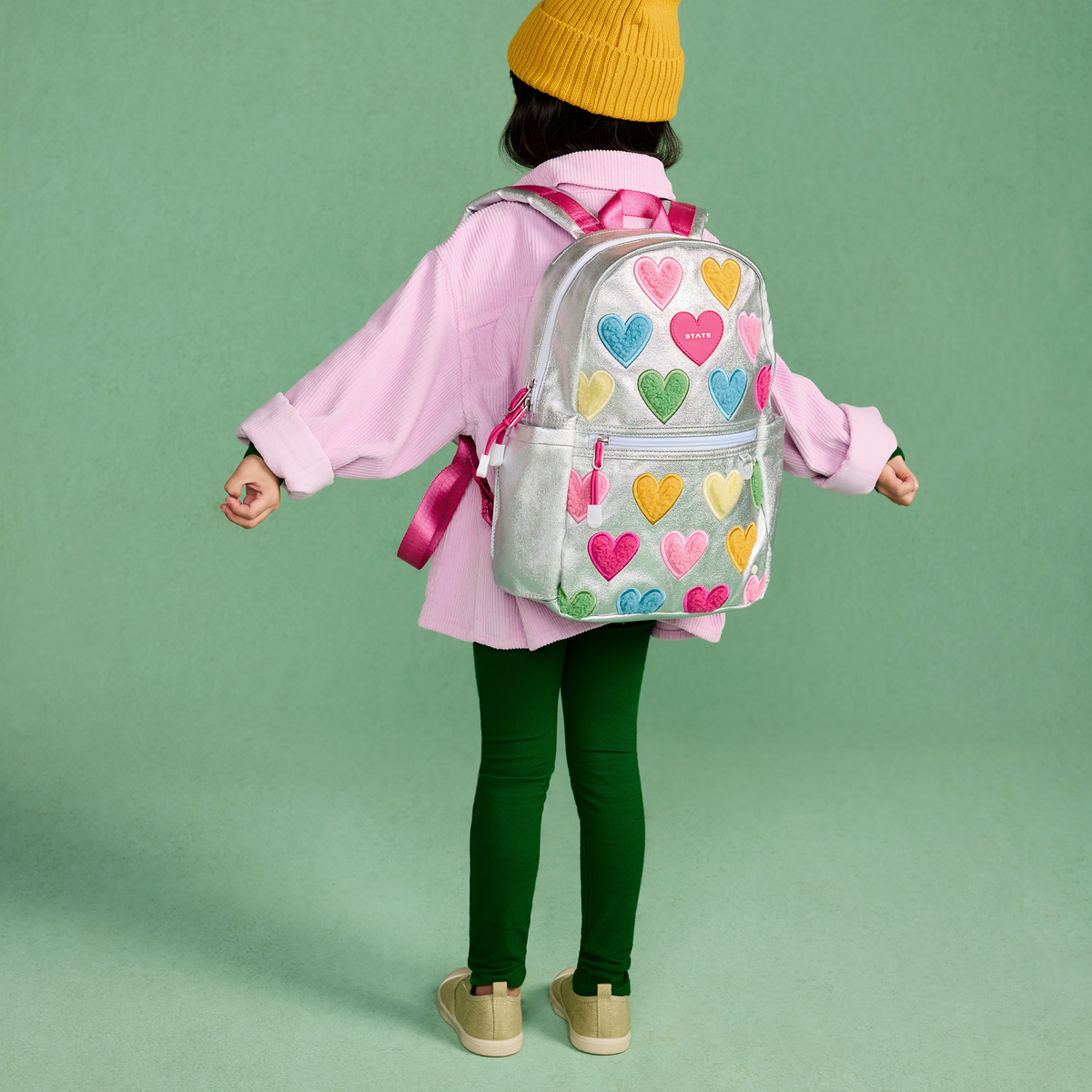 girl wearing STATE Bags Kane Mini Backpack Happy Fuzzy Hearts