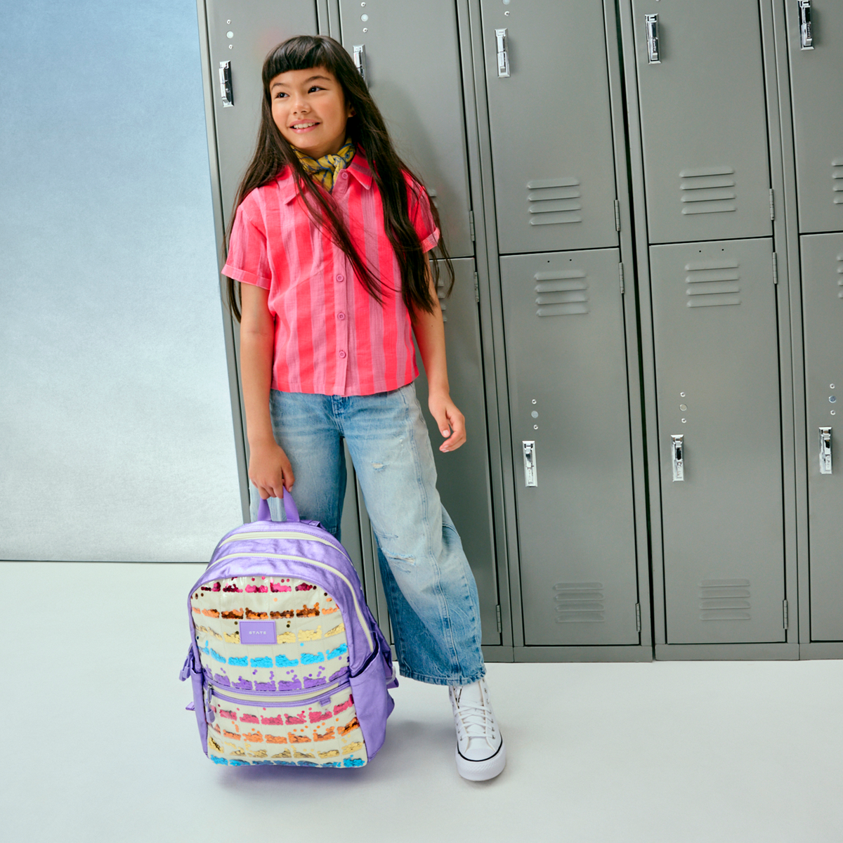 girl holding STATE bags lilac quilted sequin kane double pocket backpack