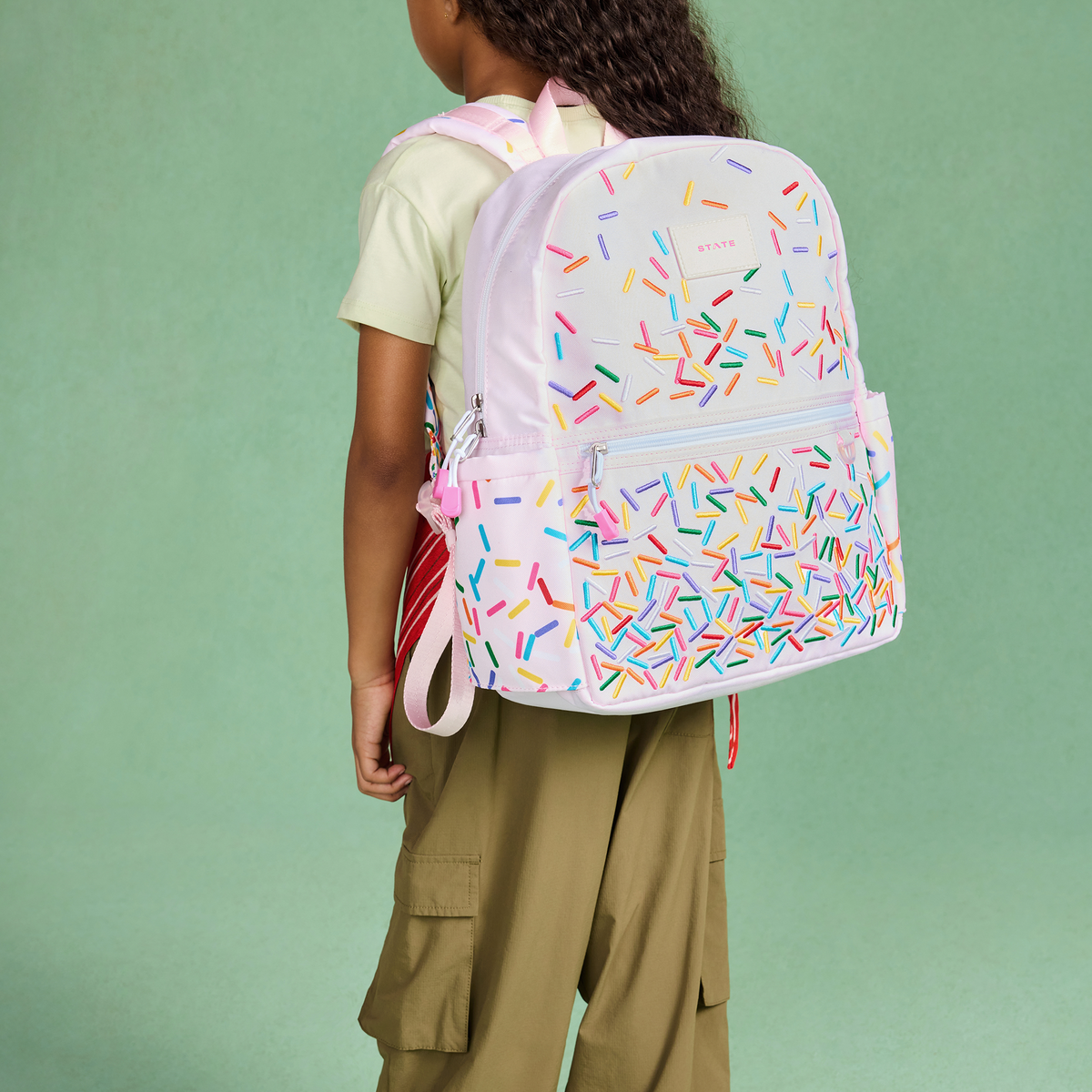 girl wearing STATE Bags kane backpack sprinkles