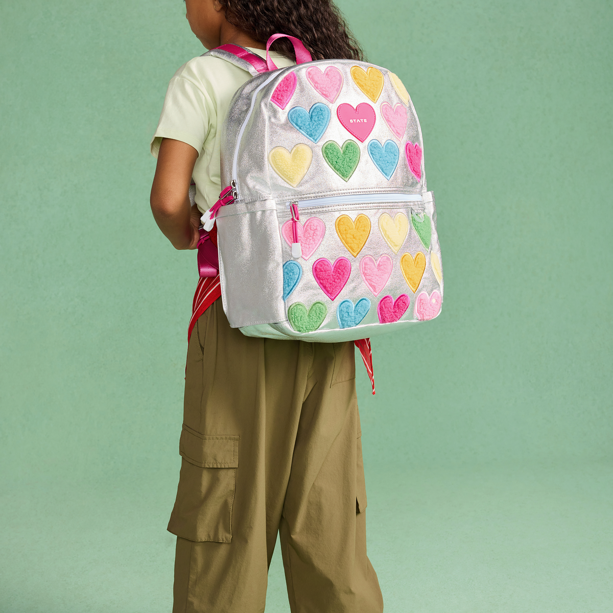 girl wearing STATE Bags Kane Backpack Happy Fuzzy Hearts
