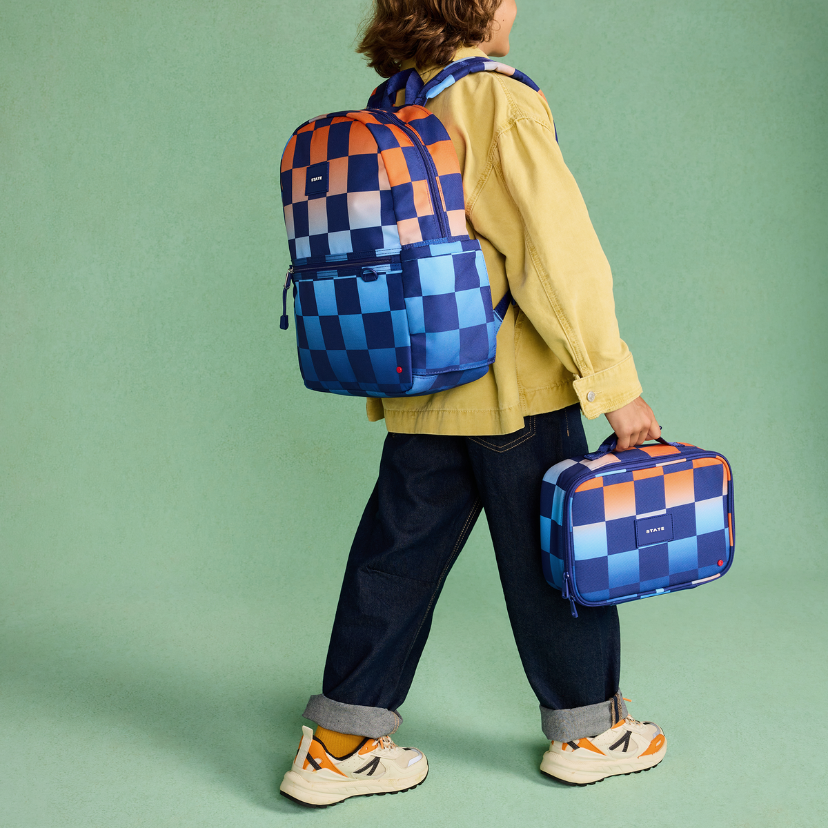 boy wearing STATE Bags Kane backpack gradient checkerboard