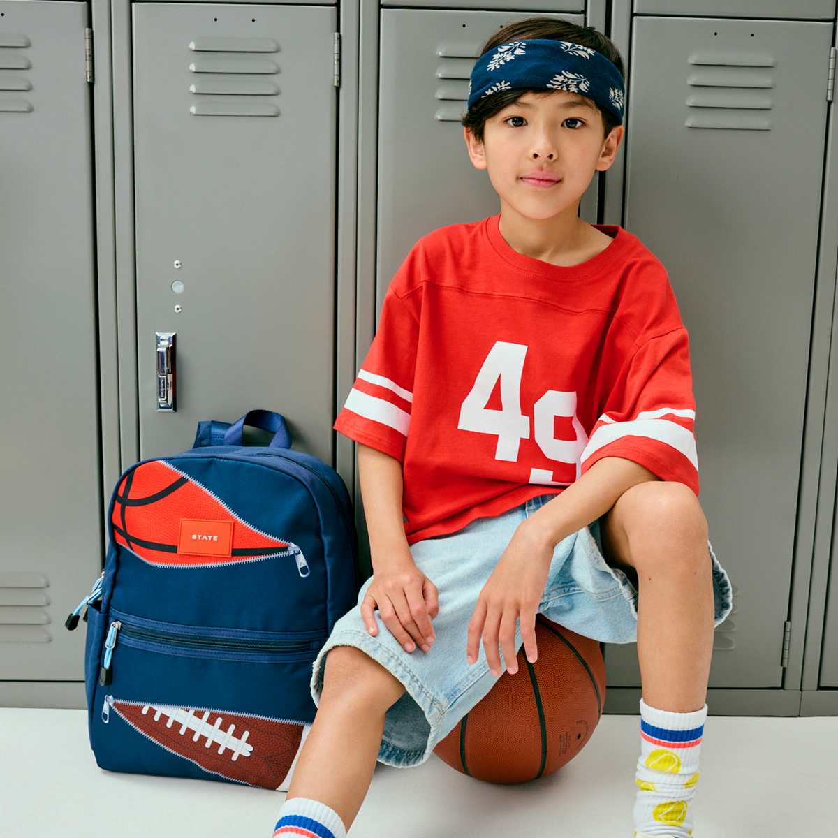 boy sitting with kane backpack sports