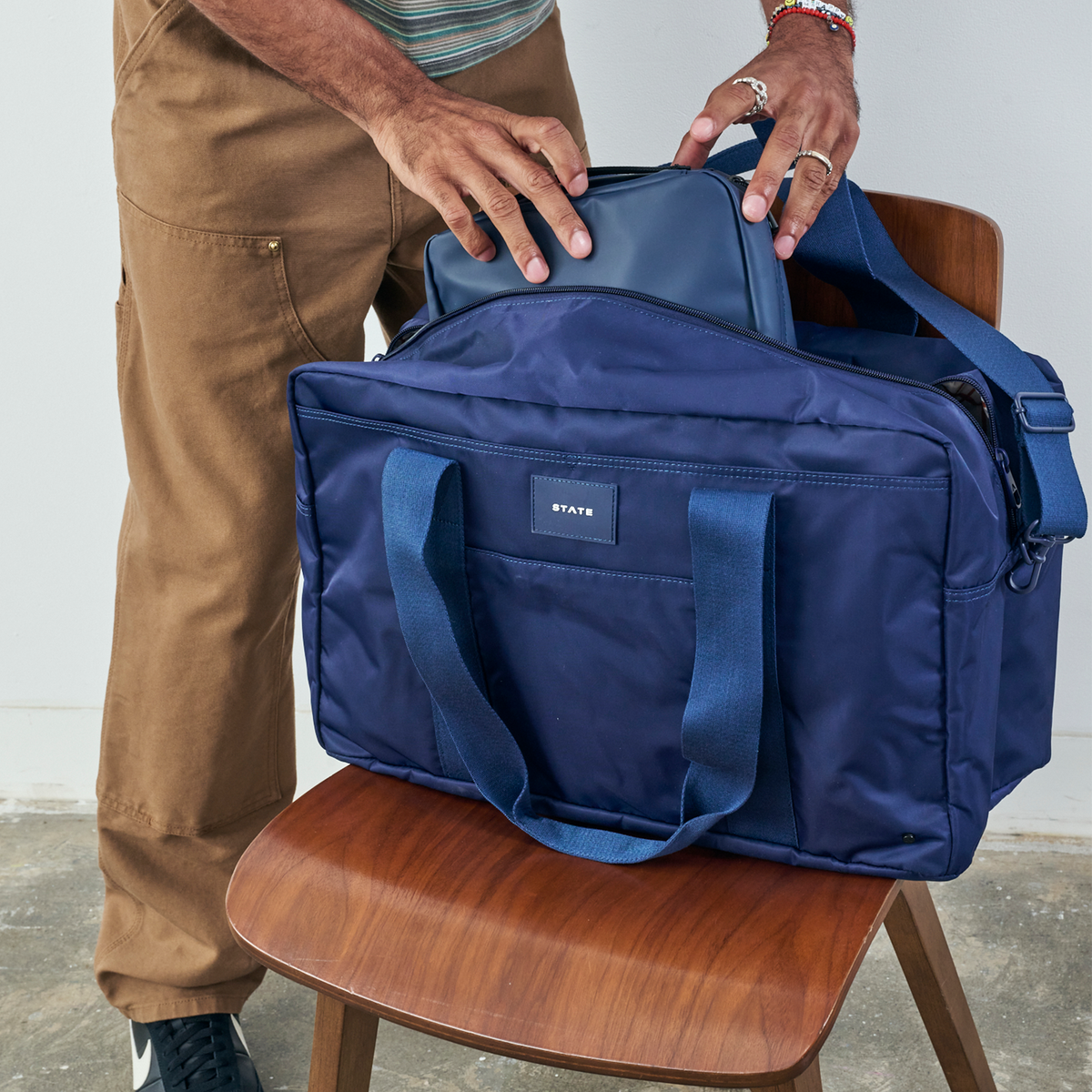 Man packing STATE Bags wellington weekender navy 